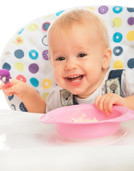 Happy baby child eats itself with a spoon — Stock Photo, Image