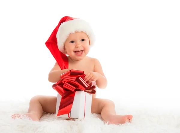 Happy baby in a Christmas hat with a gift isolated — Stock Photo, Image