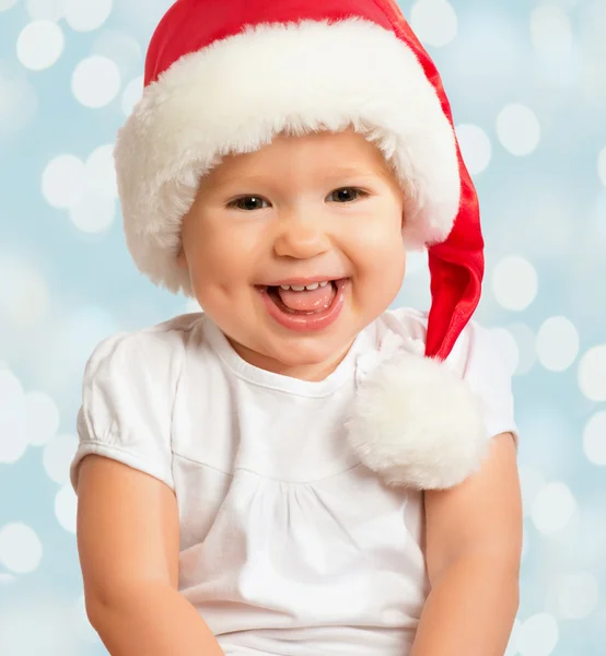 Beautiful funny baby in a Christmas hat on blue — Stock Photo, Image