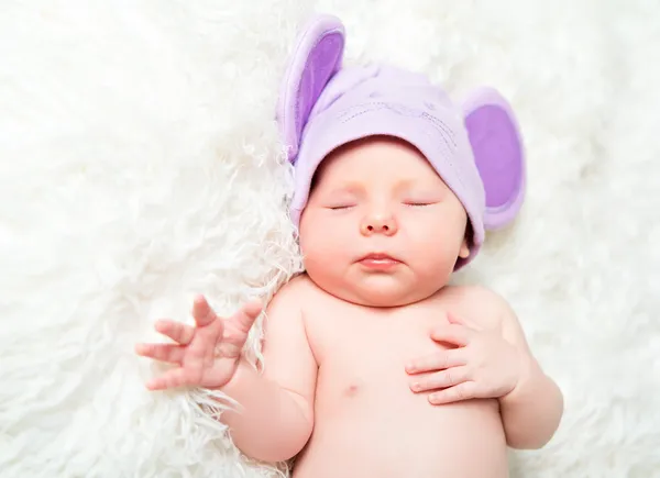 Söta nyfödda barnet sover i en hatt med öron — Stockfoto