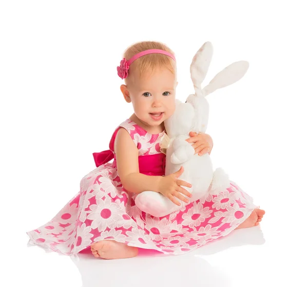 Niña abrazando a un conejo de juguete aislado en blanco — Foto de Stock