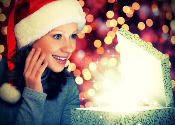 Happy woman in a Christmas cap opens the magic box — Stock Photo, Image