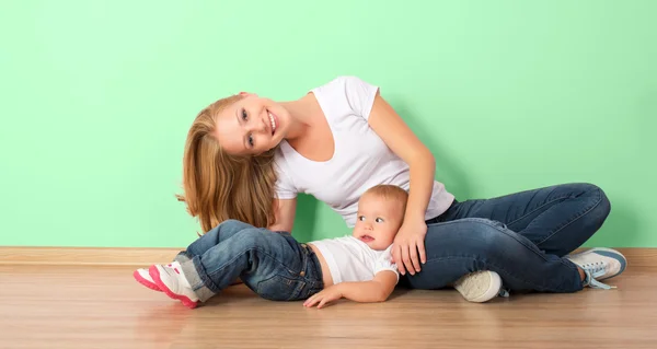 Gelukkige familie van moeder en kind zittend op de vloer in een empt — Stockfoto