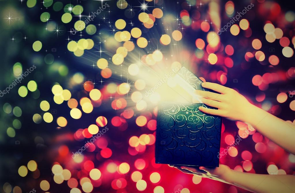 Magic gift box with lights in their hands Stock Photo by ©evgenyataman