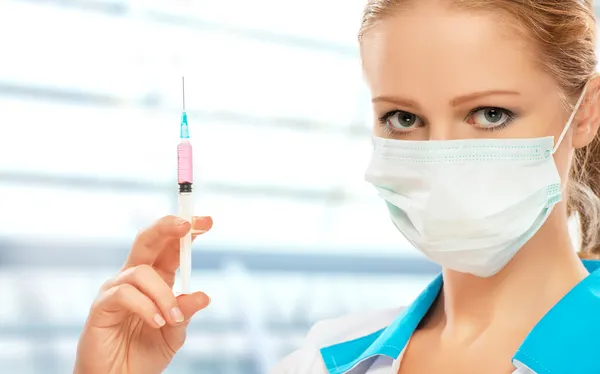 Kvinna läkare i en mask med en spruta med vaccin — Stockfoto