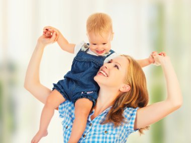 mutlu bir aile. Bebek annesi omuz ata biner gibi oturur.