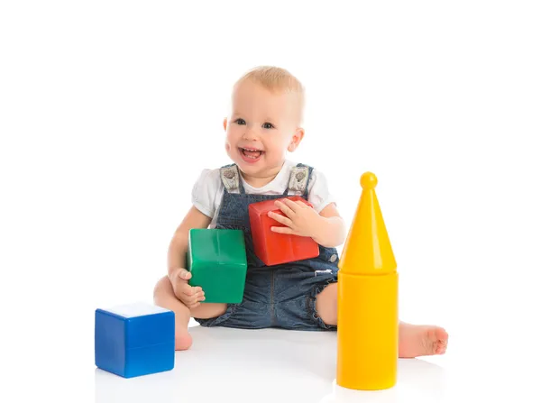 Счастливый веселый ребенок играет с блоками кубики изолированы на белом — стоковое фото