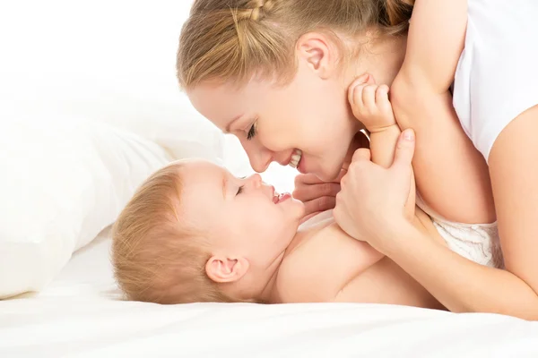 Boldog család anya és a baba, szórakoztató játék, nevető, ágy — Stock Fotó