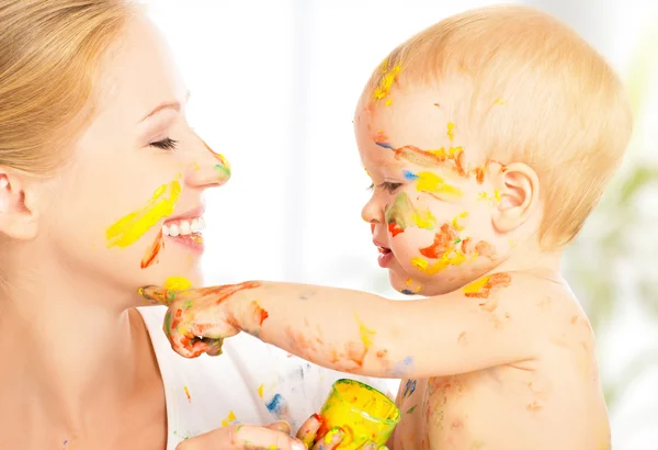 Happy dirty baby draws paints on her face of mother — Stock Photo, Image