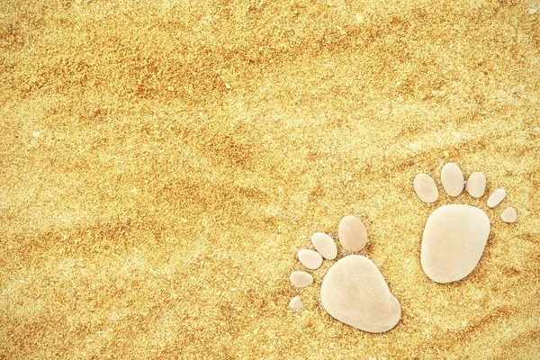 Footprints of stones on yellow sand on the beach in summer — Stock Photo, Image