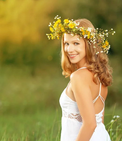 Hermosa mujer en corona de flores se encuentra en la hierba verde hacia fuera — Foto de Stock