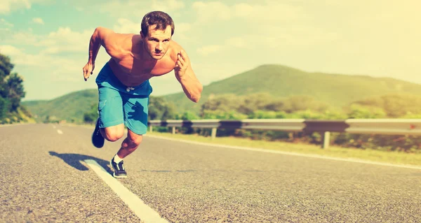 Hombre atleta corriendo en la naturaleza al atardecer — Foto de Stock