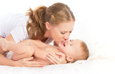 mutlu aile anne ve bebek eğleniyor oynarken, yatağa gülüyor
