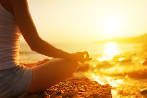 Hand av kvinna mediterar i en yogaställning på stranden — Stockfoto