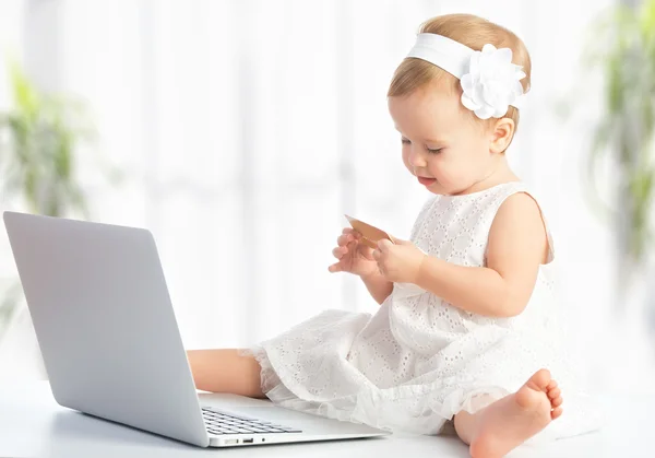 Baby girl with laptop and credit card shopping on Internet — Stock Photo, Image