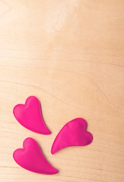 Tres corazones rojos en una tabla de madera — Foto de Stock