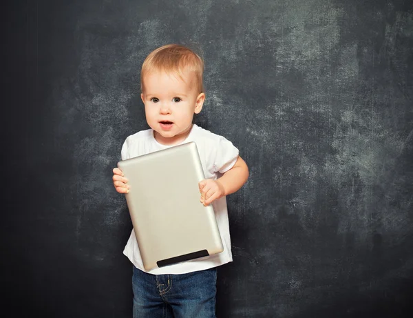 Baby with tablet computer in the hands of empty chalkboard — Stock Photo, Image