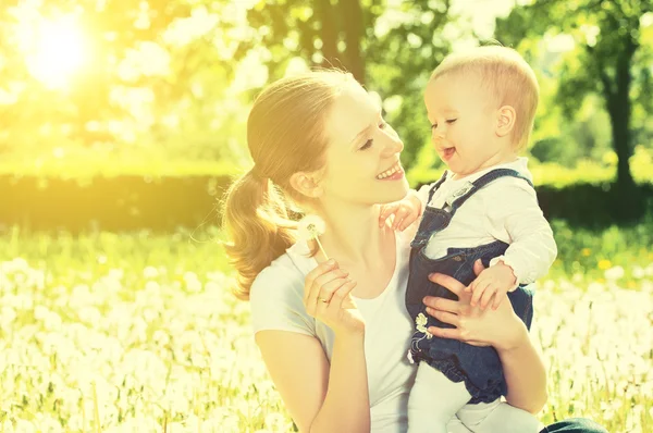 Gelukkig babymeisje in een krans op weide met gele bloemen op t — Stockfoto