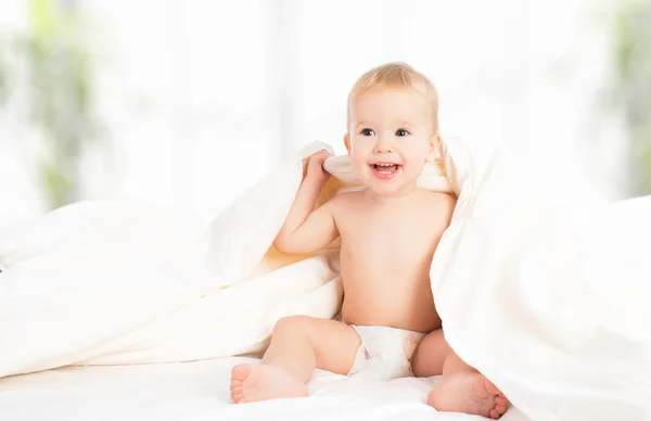 Bebé feliz debajo de una manta riendo — Foto de Stock