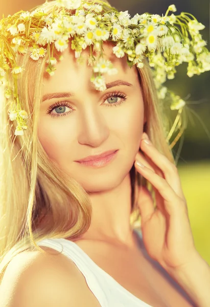 Hermosa mujer en corona de flores se encuentra en la hierba verde hacia fuera — Foto de Stock