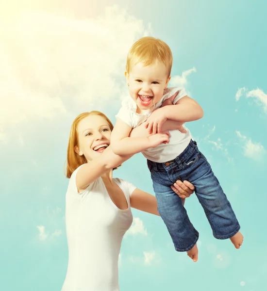 Mutlu bir aile. Anne bebek gökyüzünde yukarı atar. — Stok fotoğraf