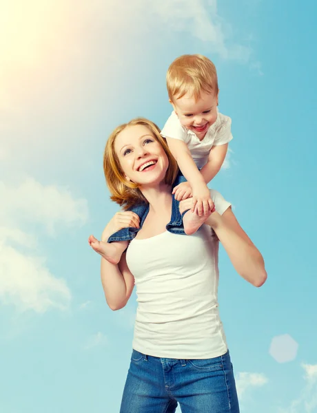 Happy family. baby sits astride the shoulders of the mother and — Stock Photo, Image