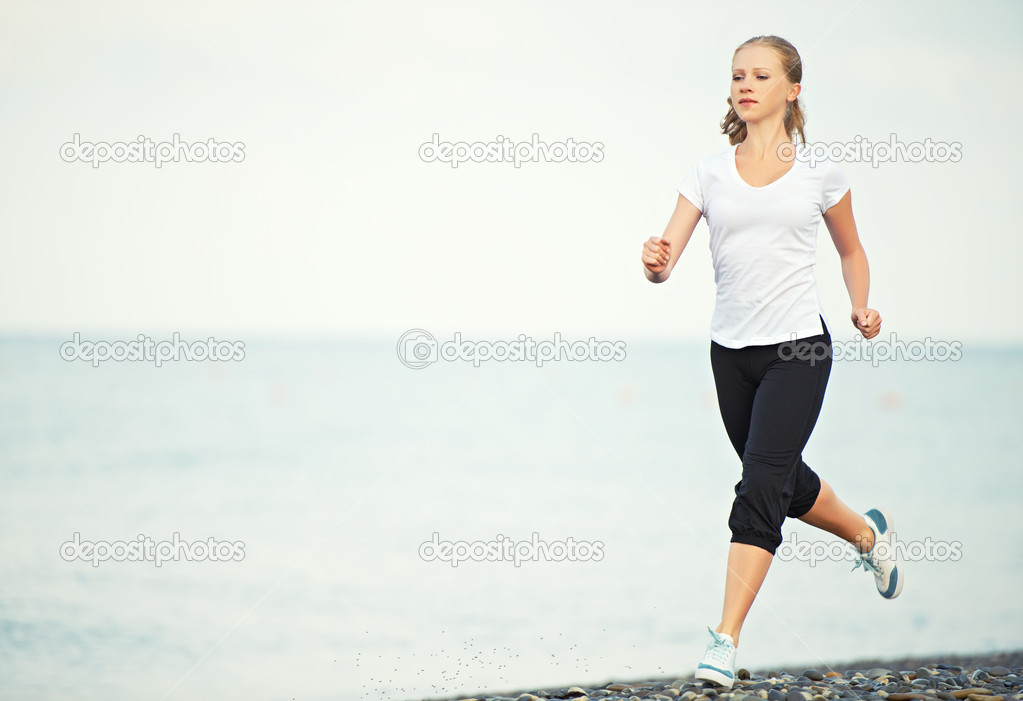 young woman running on the beach on the coast of the Sea