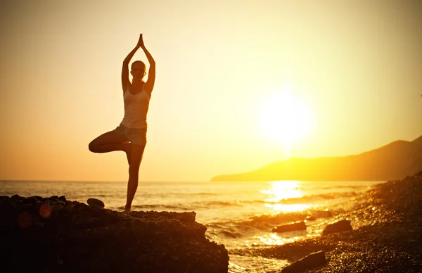 Mujer haciendo yoga en la playa al atardecer —  Fotos de Stock