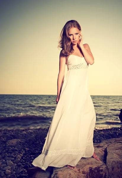 Donna in abito bianco sulla spiaggia in riva al mare — Foto Stock