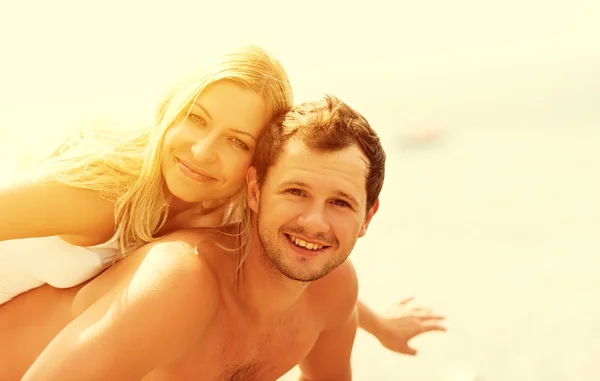 Happy family couple in love hugging and laughing on the beach — Stock Photo, Image