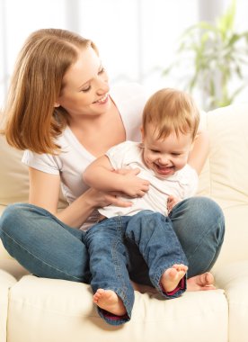 mutlu bir aile. Anne ve bebek kızı evde kanepe