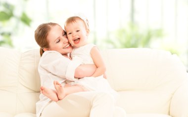 mutlu bir aile. Anne ve bebek kızı koltukta çalış
