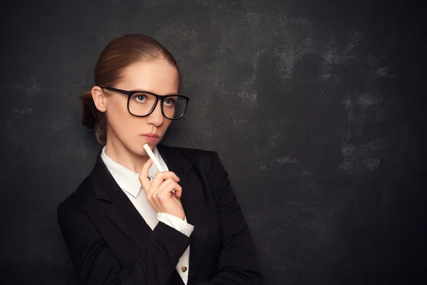 Business woman teacher with glasses and a suit with chalk   at a — Stock Photo, Image