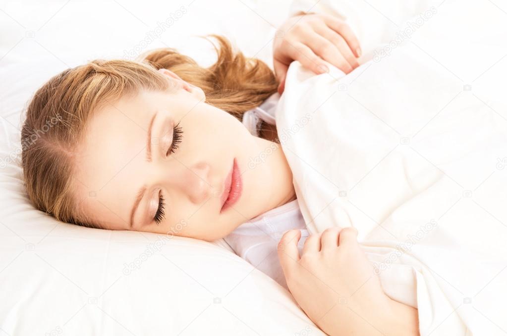beautiful woman sleeping and smiles in his sleep in  bed 