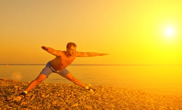 Athlète pratiquant, faisant du sport et du yoga sur la plage aux soleils — Photo