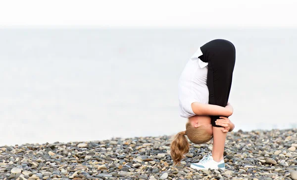 Kumsalda Yoga ve spor egzersizleri yapıyor kadın — Stok fotoğraf