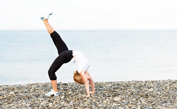 Kumsalda Yoga ve spor egzersizleri yapıyor kadın — Stok fotoğraf