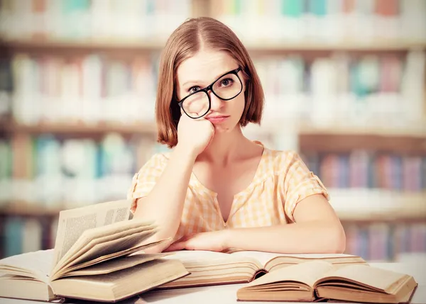 Cansado engraçado menina estudante com óculos leitura livros — Fotografia de Stock