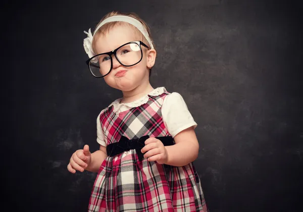 Grappig meisje leerling in glazen op blackboard — Stockfoto