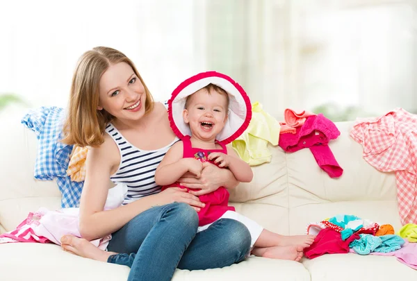 Glad mamma och baby flicka med kläder redo för att resa på — Stockfoto