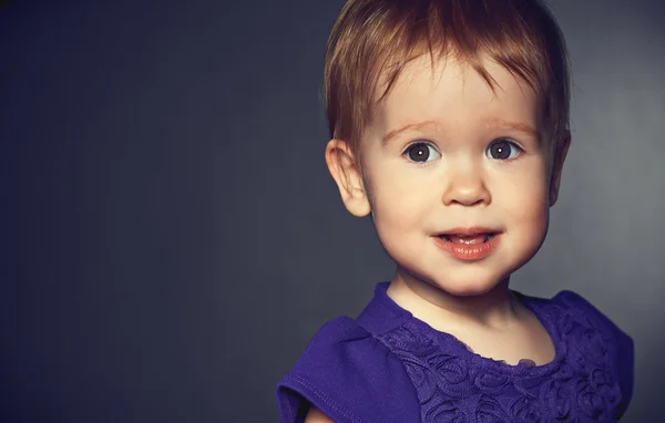 Beautiful happy little girl in a purple dress — Stock Photo, Image