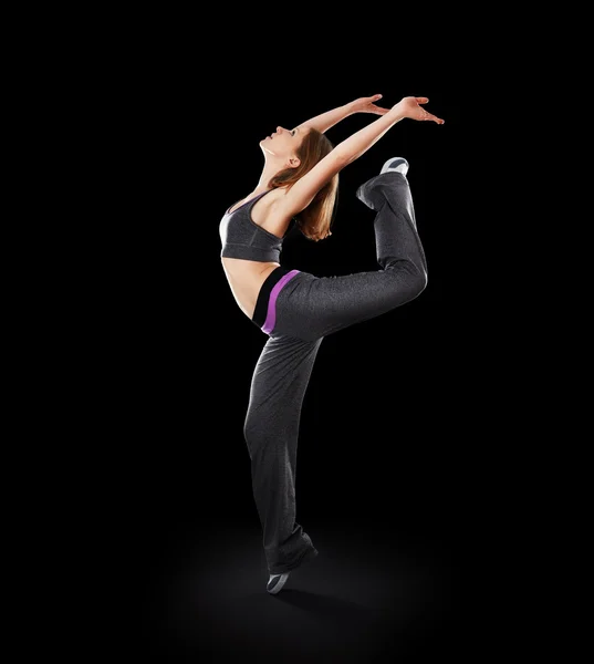 Жінка танцює сучасний танець, стрибає на чорному — стокове фото