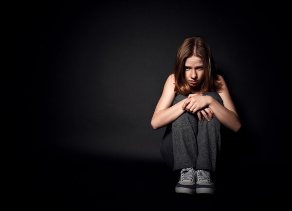 woman in depression and despair crying on black dark