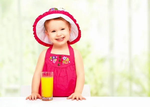 Baby girl drinking orange juice in the summer — Stock Photo, Image