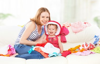 happy  Mother and baby girl with clothes ready for traveling on  clipart