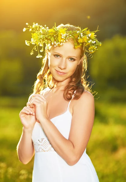 Belle femme en couronne de fleurs dans l'herbe verte en plein air — Photo