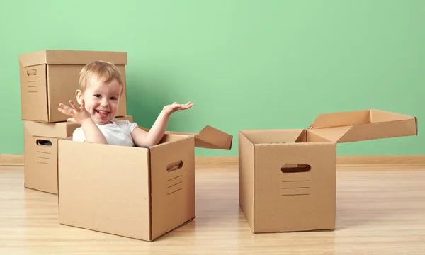 Bir karton kutu içinde oturan mutlu bebek toddler — Stok fotoğraf
