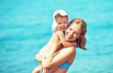 Sahilde mutlu bir aile. Anne ve bebek kız  