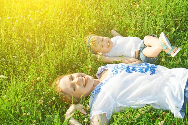 Familia feliz en la naturaleza. madre e hija del bebé están jugando en el —  Fotos de Stock