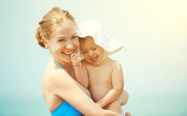 Lycklig familj på stranden. mamma och baby dotter — Stockfoto